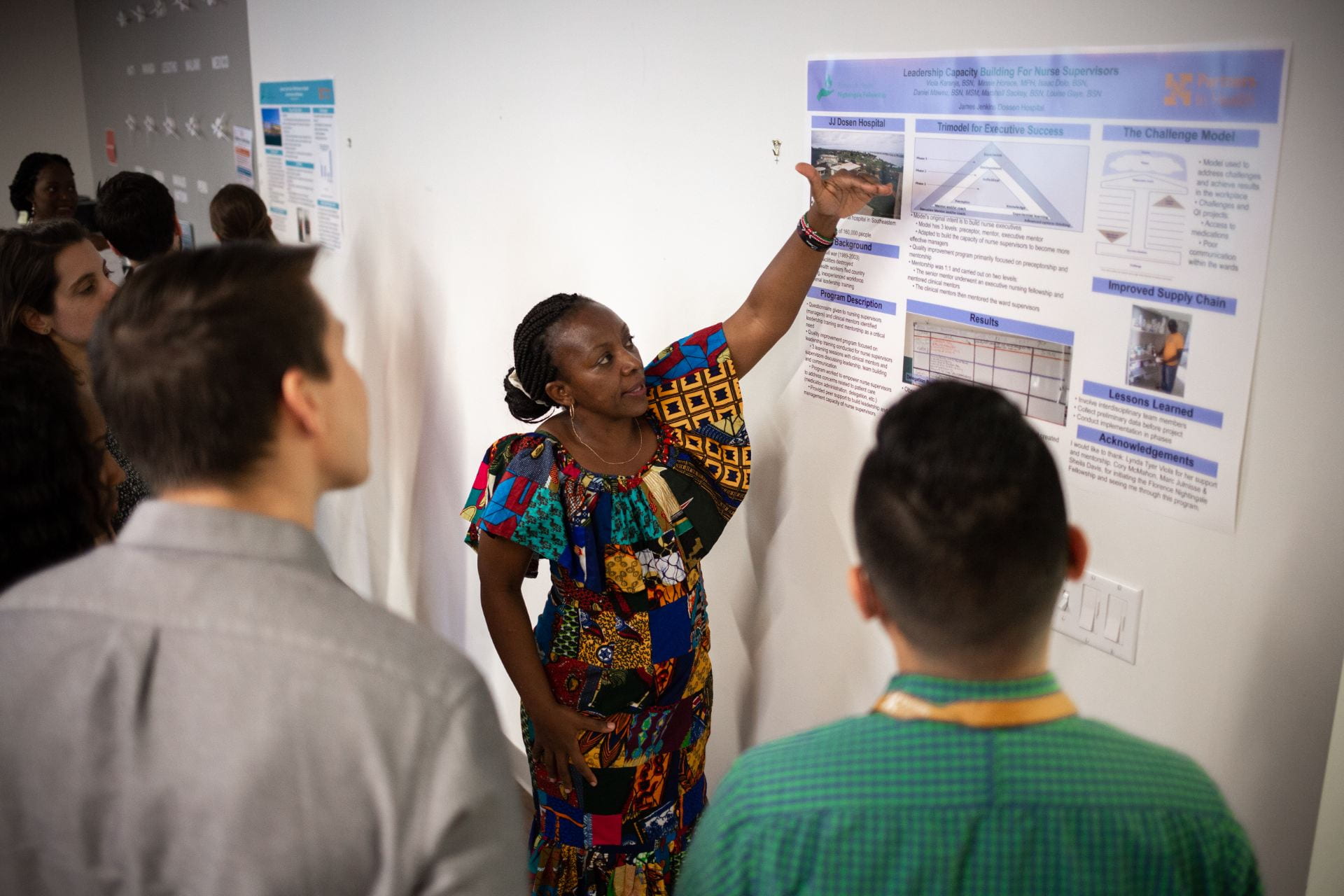 woman giving a poster presentation to a group