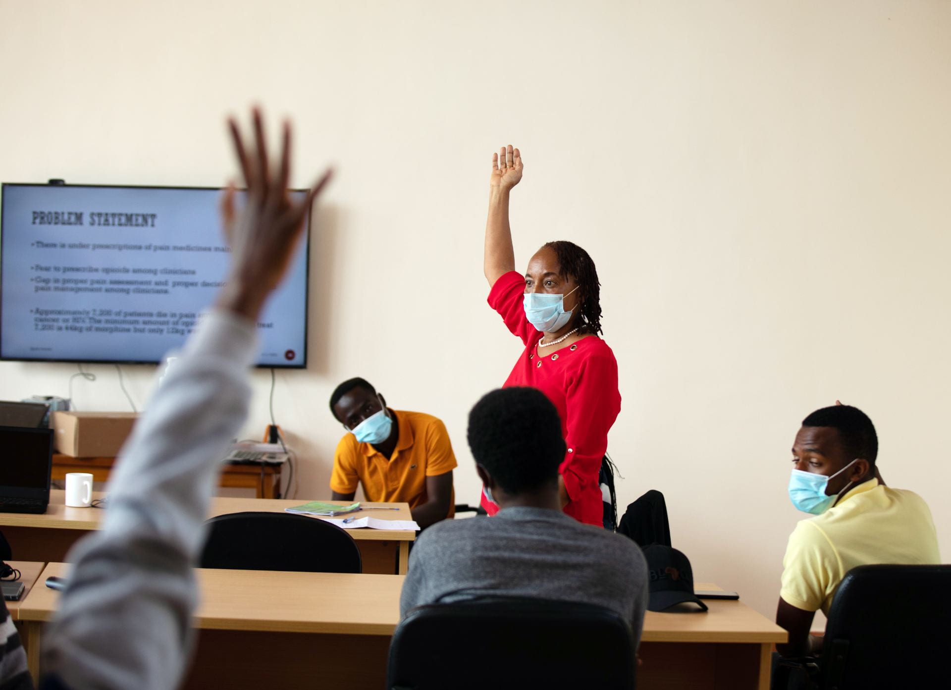 woman raising her hand while teaching class
