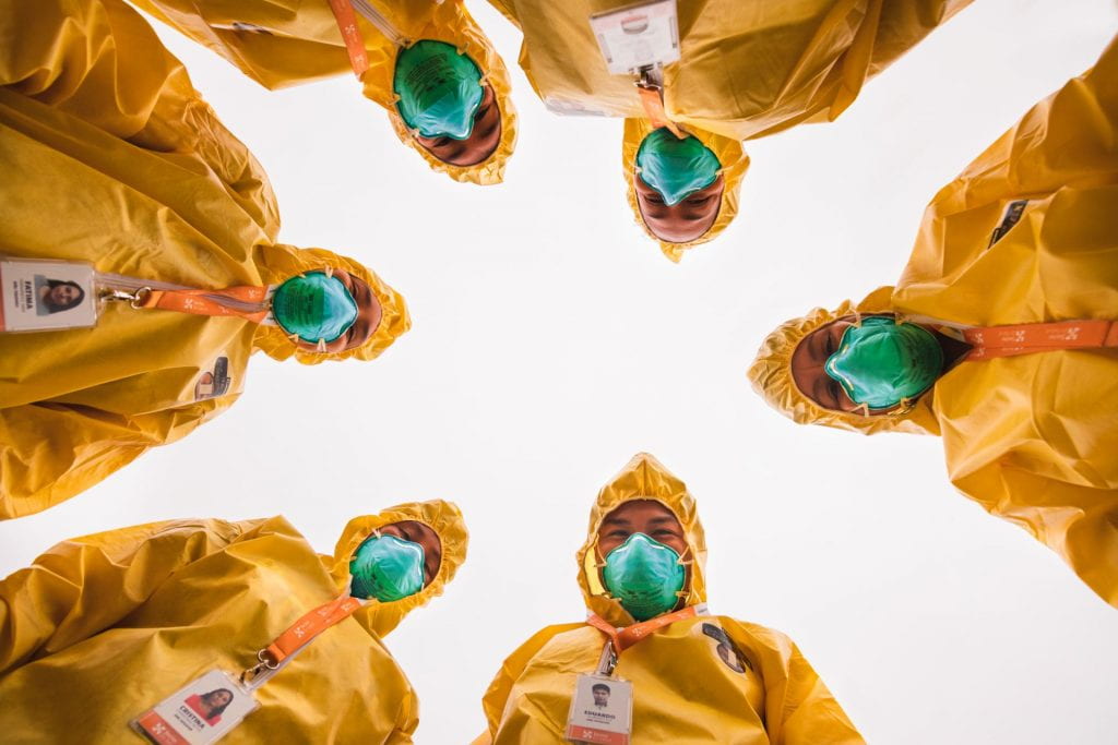 six people in hazmat suits looking down at the camera