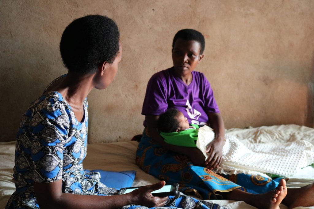 community health worker consults mother during home visit