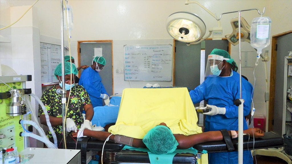 two surgeons operating on patient in liberia